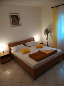um quarto com uma cama grande e almofadas amarelas em Apartments by the sea Grscica, Korcula - 4487 em Prizba