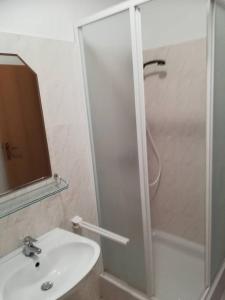 a bathroom with a shower and a white sink at Apartment Grscica 4487a in Prizba