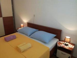 a bedroom with a bed with two pillows on it at Apartments by the sea Lumbarda, Korcula - 4369 in Lumbarda