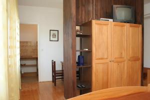 Cette chambre dispose d'une télévision et d'une étagère en bois. dans l'établissement Studio Korcula 4356a, à Korčula