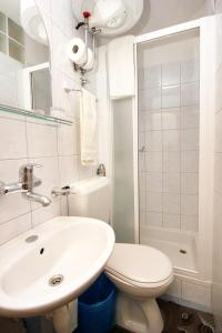 a white bathroom with a toilet and a sink at Double Room Racisce 4341a in Račišće