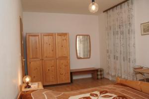 a bedroom with a wooden cabinet and a mirror at Double Room Korcula 4356c in Korčula