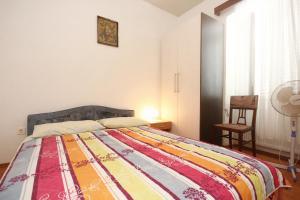 a bedroom with a bed with a colorful blanket on it at Double Room Lumbarda 4436d in Lumbarda