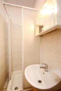 a white bathroom with a sink and a shower at Double Room Lumbarda 4436d in Lumbarda