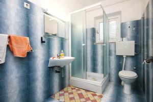 ein Bad mit einem WC, einem Waschbecken und einer Dusche in der Unterkunft Apartments by the sea Lumbarda, Korcula - 4440 in Lumbarda