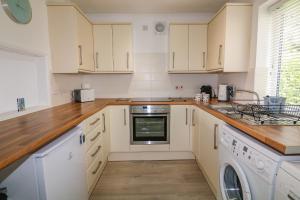 uma cozinha com armários brancos e uma máquina de lavar louça em Waters Reach em Kingsbridge