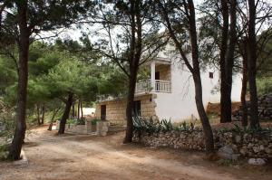 a house with a balcony in the middle of trees at Seaside apartments with a swimming pool Lumbarda, Korcula - 4404 in Lumbarda
