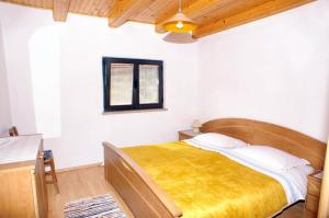 a bedroom with a bed with a yellow blanket at Seaside apartments with a swimming pool Lumbarda, Korcula - 4404 in Lumbarda +34 photos
