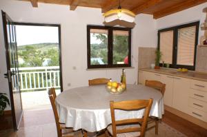 a kitchen and dining room with a table and chairs at Seaside apartments with a swimming pool Lumbarda, Korcula - 4404 in Lumbarda