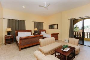 a hotel room with two beds and a living room at Turtle Bay Dive Resort in Moalboal