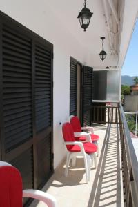 uma fila de cadeiras vermelhas sentadas numa varanda em Apartment Orebic 4494d em Orebić