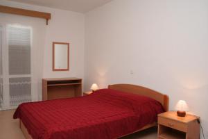 1 dormitorio con 1 cama roja y 2 mesitas de noche en Apartments with a parking space Orebic, Peljesac - 4494 en Orebić