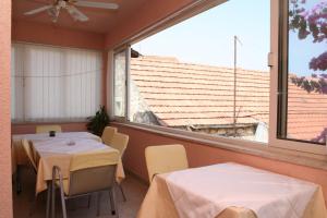 two tables and chairs in a room with a large window at Rooms by the sea Vrboska (Hvar) - 4600 in Vrboska