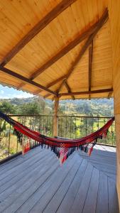 - un hamac sur une terrasse en bois avec vue dans l'établissement Balcones de El Carrizal, à El Cocuy
