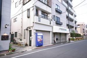 a building with a blue door on the side of a street at Tamanoi in Tokyo