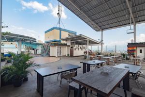 a patio with tables and chairs on a roof at RedDoorz Premium near Bandung Station in Bandung