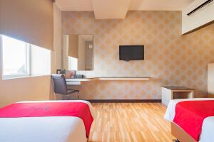 a hotel room with two beds and a television at RedDoorz Premium near Bandung Station in Bandung
