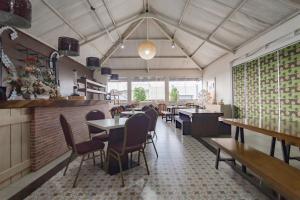 a restaurant with tables and chairs in a room at RedDoorz Premium near Bandung Station in Bandung