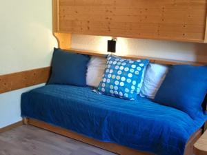 łóżko z niebiesko-białymi poduszkami w obiekcie Studette cosy pour 2 pers. - Centre station Arc 1800 - Ski aux pieds - Wifi gratuit - FR-1-346-511 w mieście Arc 1800