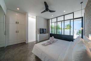Un dormitorio con una cama y un ventilador de techo. en Loft Charly - Contemporary 1-bdr luxury loft in GREAT LOCATION, en Canggu 81 fotos más