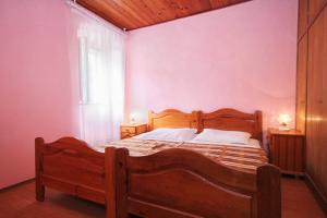 a bedroom with a wooden bed and a window at Seaside holiday house Orebic, Peljesac - 4569 in Orebić