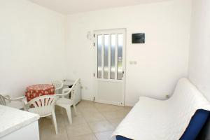 a small room with a bed and a table and chairs at Apartments by the sea Luka Dubrava, Peljesac - 4568 in Janjina