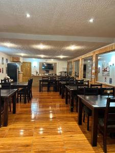 comedor con mesas y sillas de madera en Hotel Boutique Family Suites, en Panguipulli