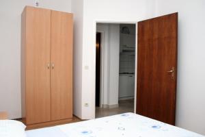 1 dormitorio con 2 armarios de madera y 1 cama en Apartment Orebic 4565f en Orebić