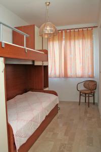 a bedroom with a bunk bed and a chair at Apartments by the sea Sreser, Peljesac - 4557 in Janjina
