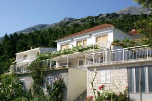 a building with balconies on the side of it at Apartments by the sea Kuciste - Perna, Peljesac - 4544 in Kučište