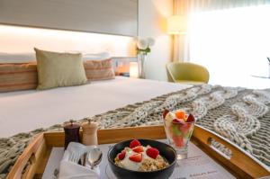 een dienblad met een schaal ontbijtgranen en fruit op een bed bij The Point Brisbane Hotel in Brisbane