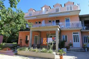 une maison orange avec un balcon au-dessus dans l'établissement Studio Zuljana 4576b, à Žuljana