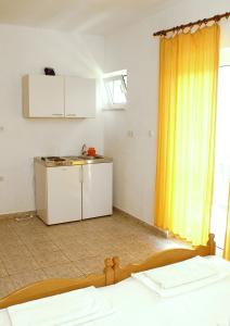 a room with a kitchen with a yellow curtain at Studio Zuljana 4576b in Žuljana