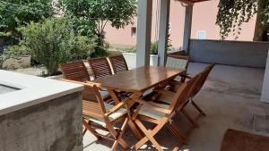 a wooden table and chairs on a patio at Apartments and rooms by the sea Zuljana, Peljesac - 4576 in Žuljana