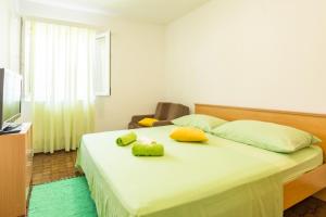 a bedroom with a bed with yellow pillows and a television at Seaside holiday house Cove Zarace - Gdinj, Hvar - 4603 in Gdinj