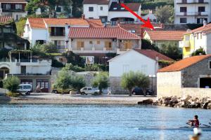 a person in a boat in the water with buildings at Double Room Jelsa 4602a in Jelsa