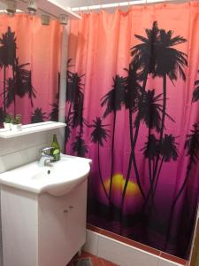 a bathroom with a pink shower curtain with palm trees at Studio Zuljana 4573b in Žuljana