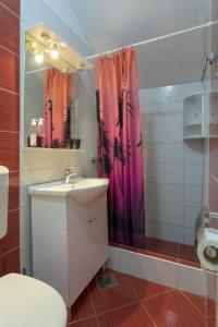 a bathroom with a sink and a pink shower curtain at Studio Zuljana 4573b in Žuljana