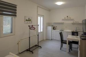 a white kitchen with a table and a table and chairs at Studio Zuljana 4573b in Žuljana