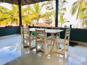 a wooden table and chairs with a view of the beach at Beach Bungalow Yala in Kirinda