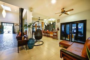 a living room with a couch and a ceiling fan at Coco Retreat Phuket Resort and Spa - SHA Plus in Chalong 