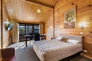 een slaapkamer met een bed en een bureau in een kamer bij Aspiring Lodge Motel in Wanaka