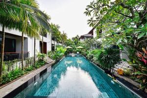 a swimming pool in the middle of a resort at Coco Retreat Phuket Resort and Spa - SHA Plus in Chalong 