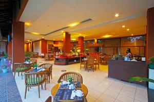 un restaurante con mesas y sillas y gente de fondo en The Jayakarta Suites Komodo Flores, en Labuan Bajo