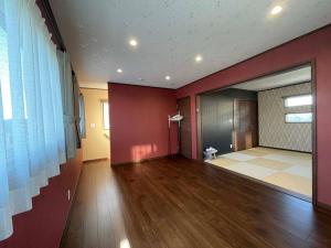 una sala de estar con paredes rojas y suelo de madera. en 【スカイテラス9-8B】 en Shima