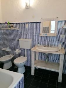 a bathroom with two sinks and a toilet and a mirror at Bados affaccio sul mare in Olbia