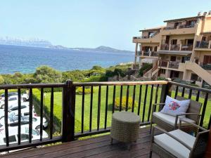 a balcony with a chair and a view of the ocean at Bados affaccio sul mare in Olbia