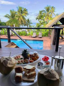 une assiette de nourriture sur une table à côté d'une piscine dans l'établissement Kaila Na Ua Resort, à Korotogo