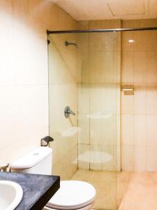 a bathroom with a shower and a toilet and a sink at RedDoorz At Hotel Gajah Mada Palu in Palu