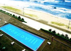 un cartello su un edificio con una spiaggia sullo sfondo di Seaspovill Resort a Samcheok